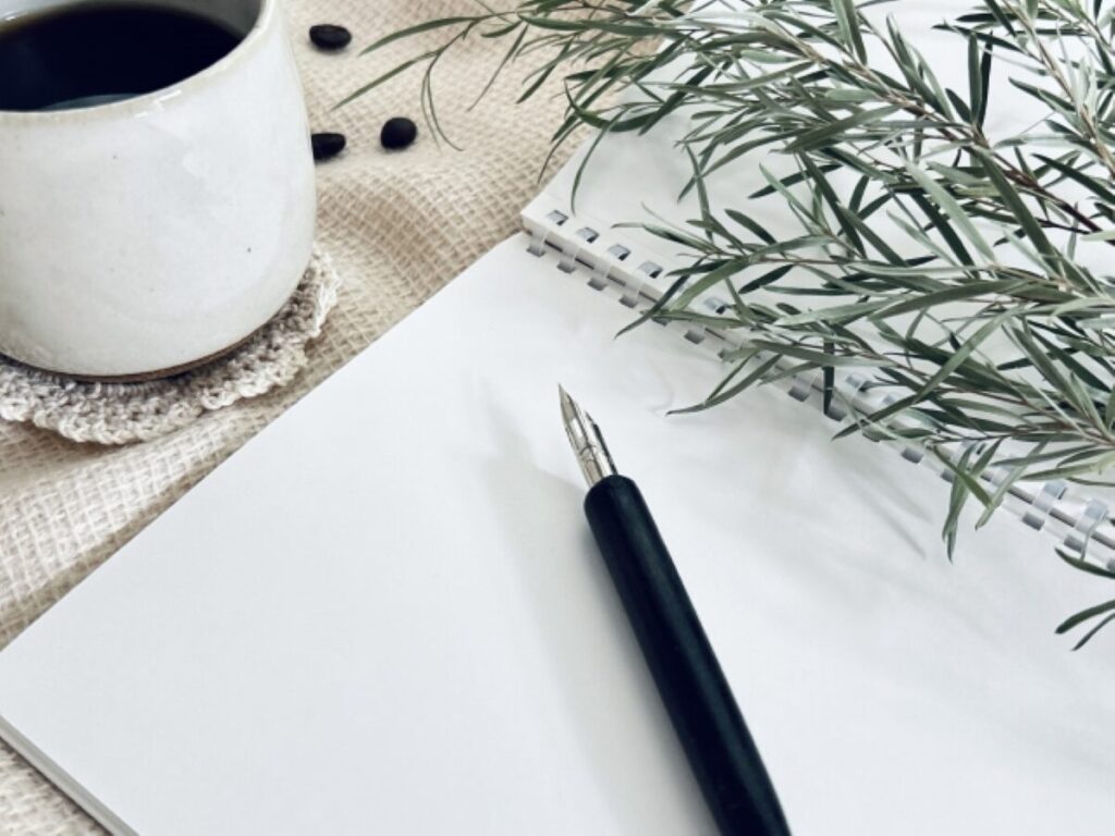 ノートとペンとコーヒーの画像